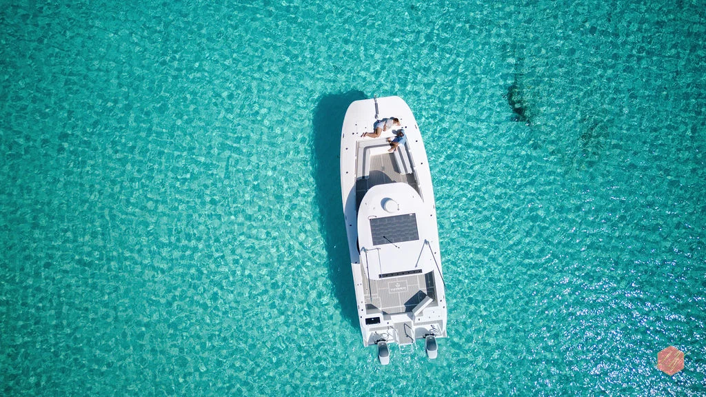 Aerial view of the family boat surrounded by crystal-clear turquoise water in Grand Bahama