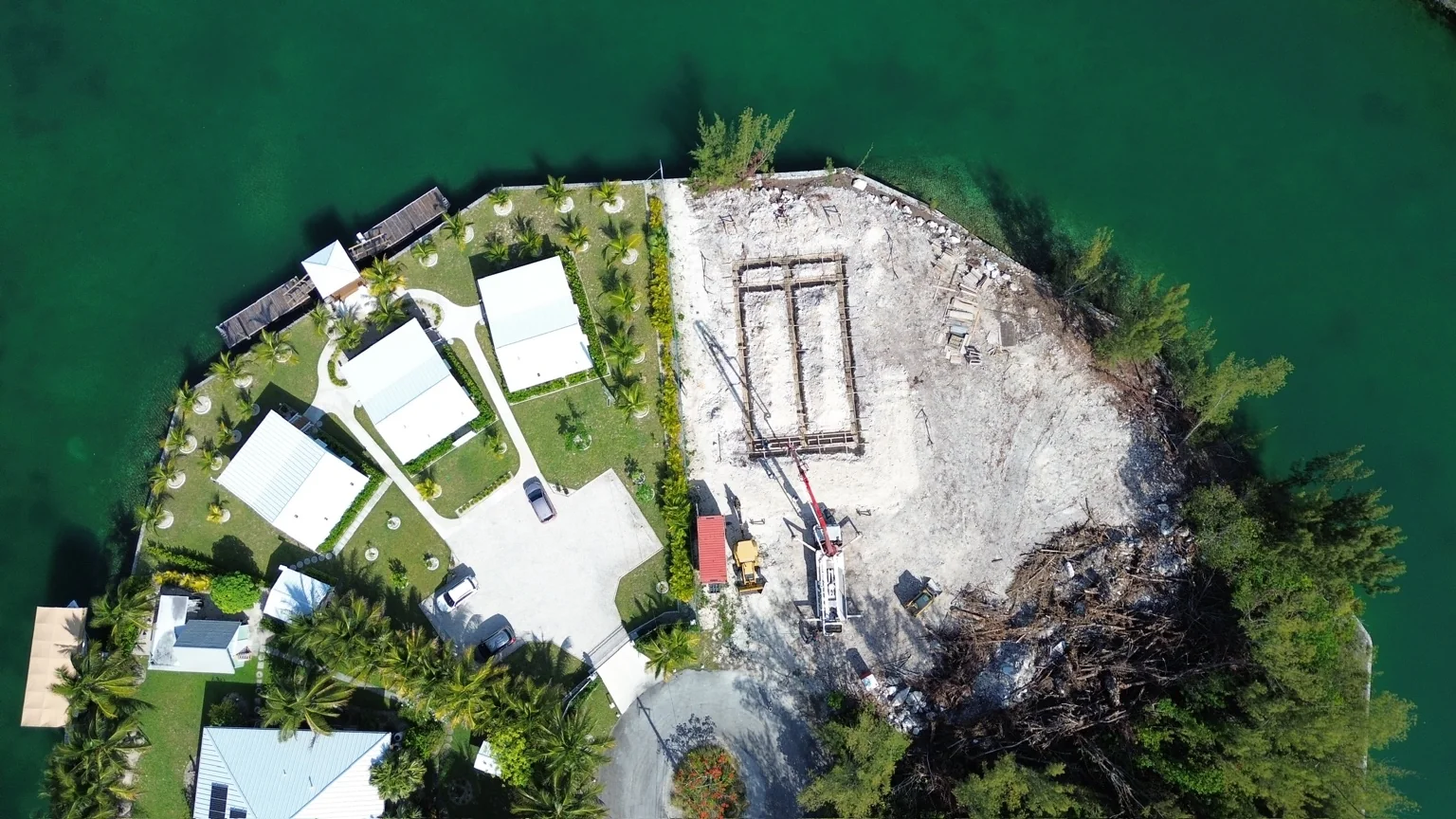 Aerial of Grand Bahama waterfront: deep green water, canal-side homes and open land ready for building