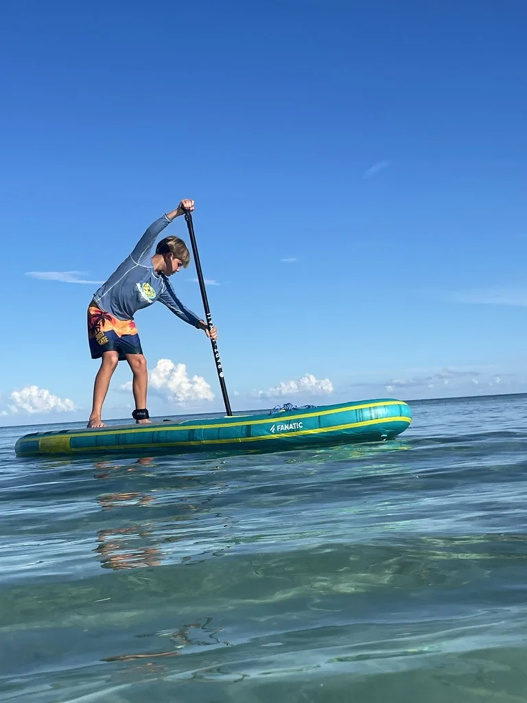 One of Pamela's children paddleboarding on the open water in Grand Bahama