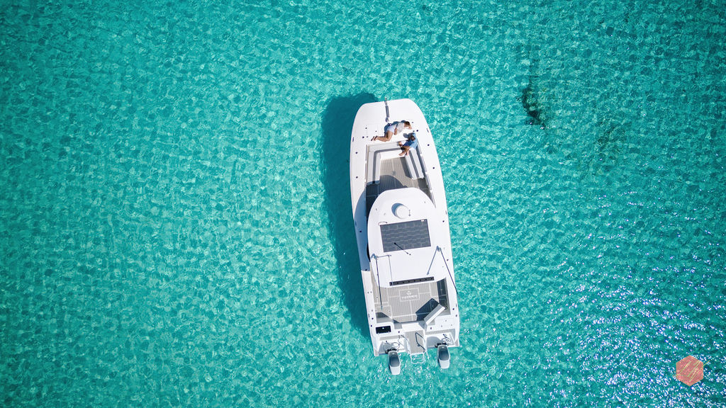 A white boat surrounded by crystal-clear turquoise Grand Bahama water