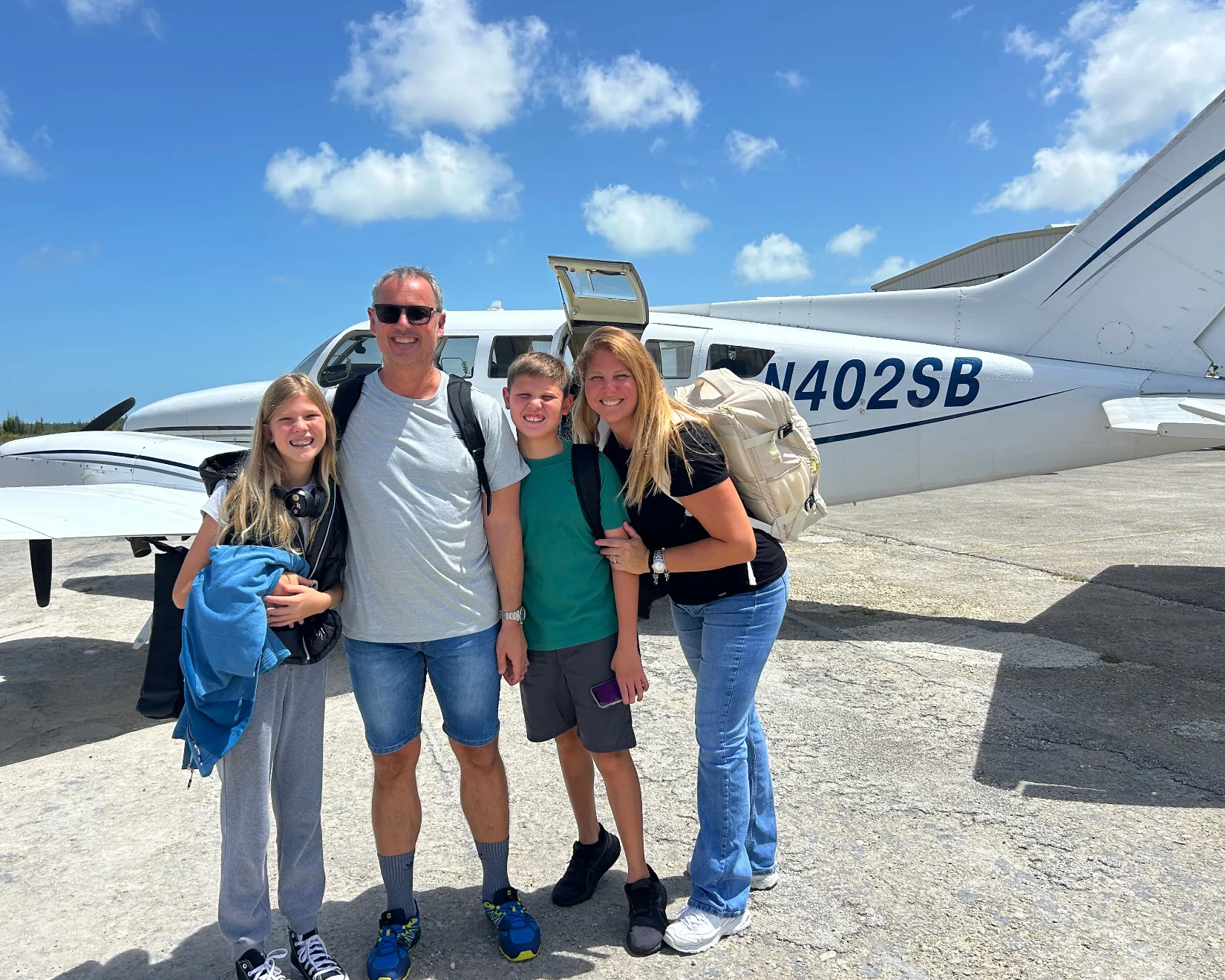 Our family standing beside a small airplane on arrival in Grand Bahama